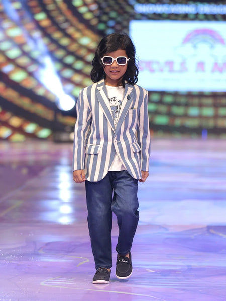 Boy walking on a runway wearing a striped blazer and sunglasses.