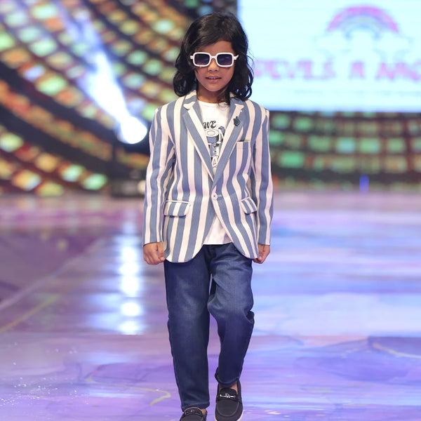 Boy walking on a runway wearing a striped blazer and sunglasses.