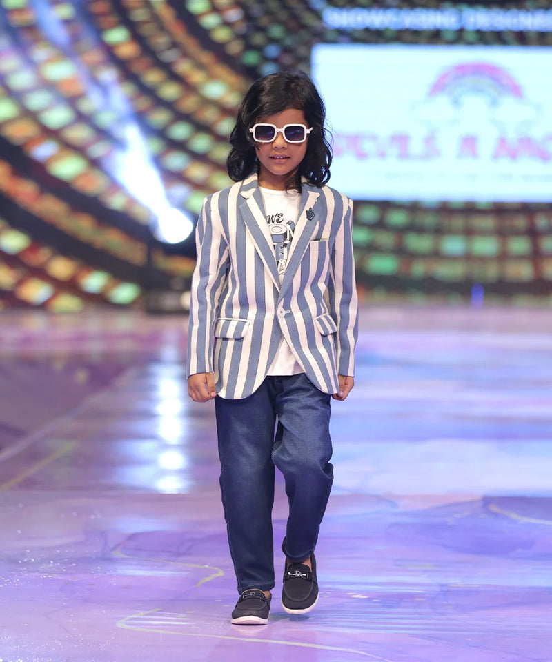 Boy walking on a runway wearing a striped blazer and sunglasses.