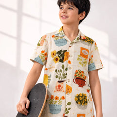 Child wearing a colorful shirt with floral and teacup patterns, holding a skateboard.