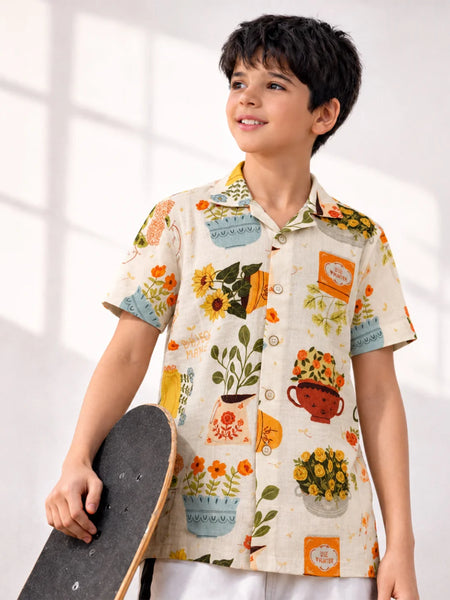 Child wearing a colorful shirt with floral and teacup patterns, holding a skateboard.