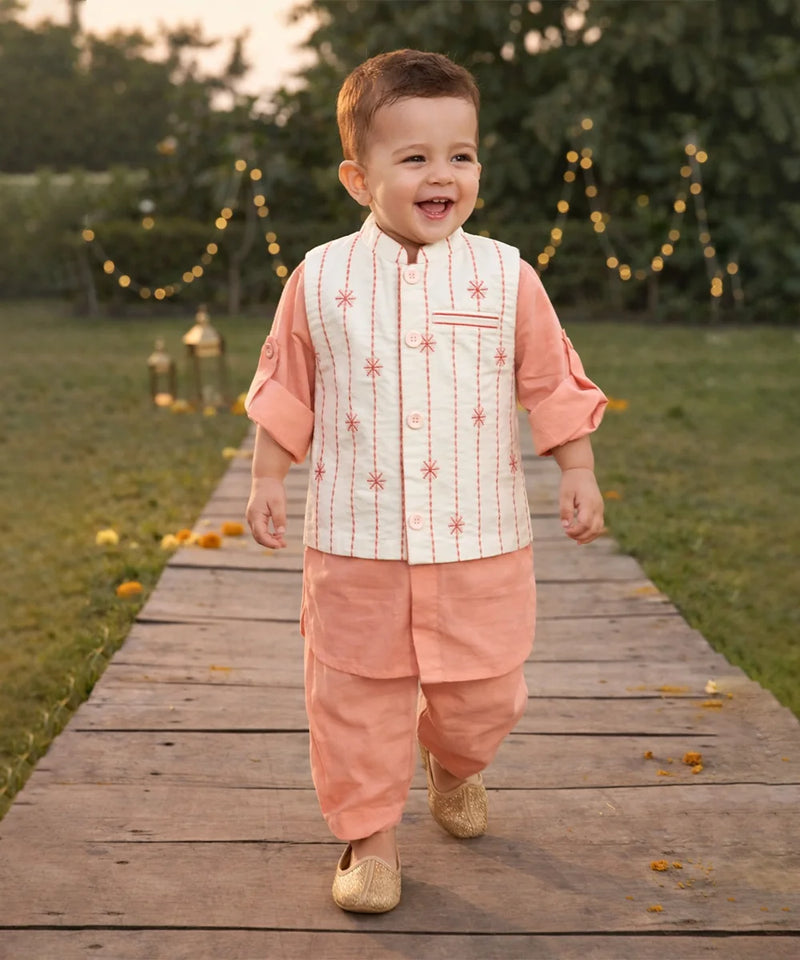 Child in traditional outfit walking on a wooden path with decorative lights in the background
