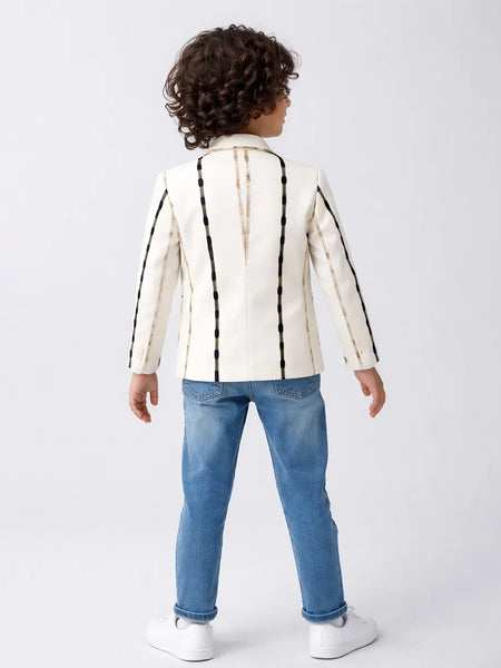 Child wearing a white jacket with black stripes and blue jeans on a white background