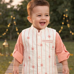 Child in traditional outfit walking on a wooden path with decorative lights in the background