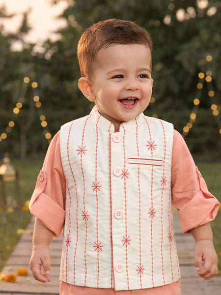 Child in traditional outfit walking on a wooden path with decorative lights in the background