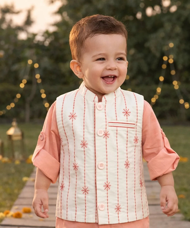 Child in traditional outfit walking on a wooden path with decorative lights in the background