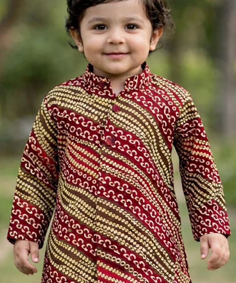 Child wearing a patterned kurta with a blurred natural background