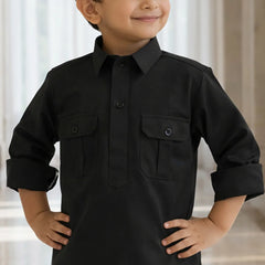 Child wearing a black long-sleeve shirt with pockets against a neutral background