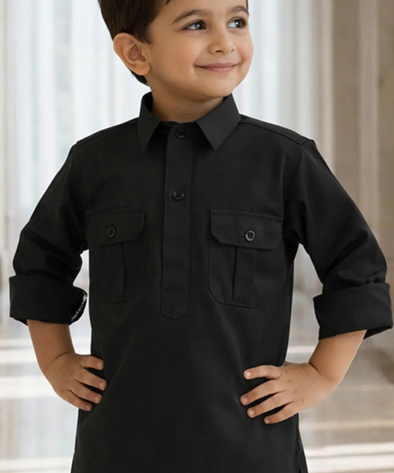 Child wearing a black long-sleeve shirt with pockets against a neutral background