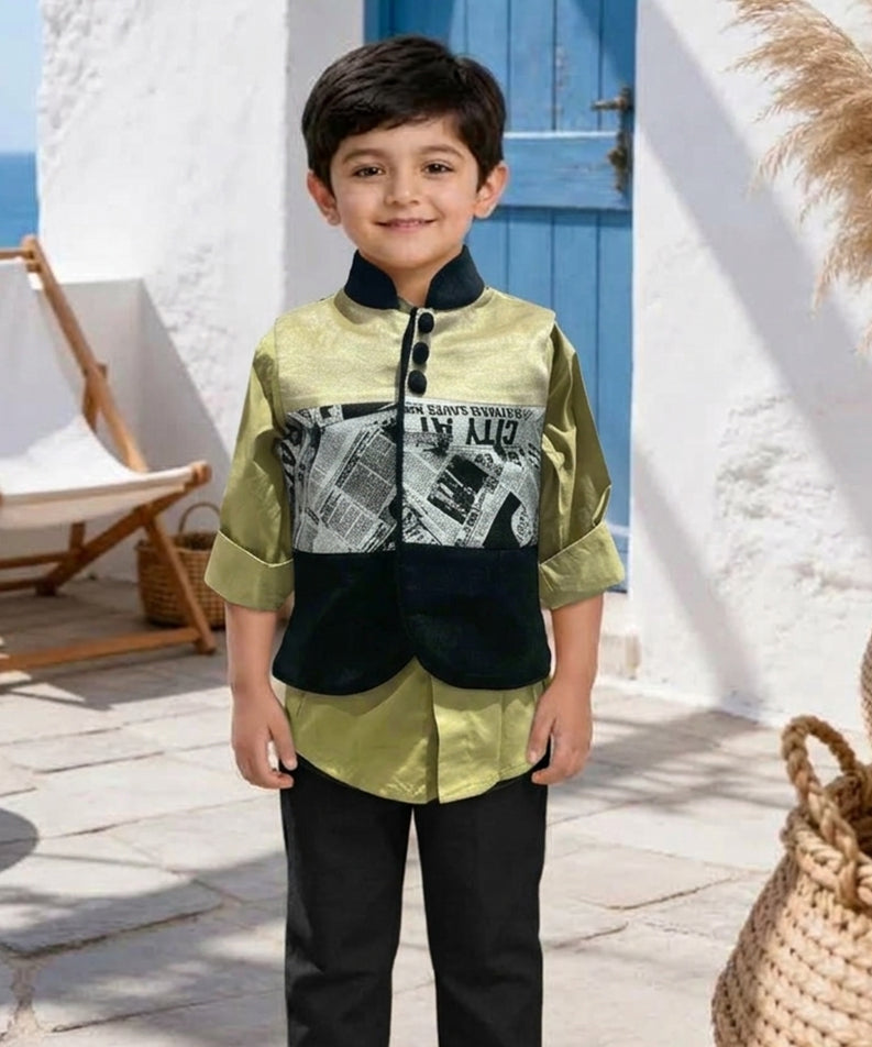 A young boy stands outdoors wearing a two-piece outfit consisting of a sage green and black jacket with a newspaper graphic print, paired with black trousers and cream sneakers.