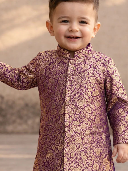 Child wearing a purple and gold traditional outfit with a blurred background