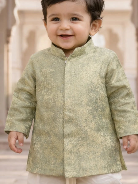 Child wearing a light green traditional outfit with a blurred architectural background