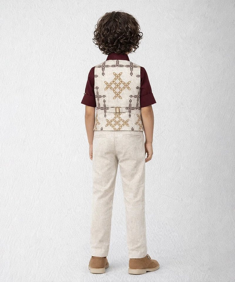 Child wearing a patterned vest over a shirt with beige pants on a white background