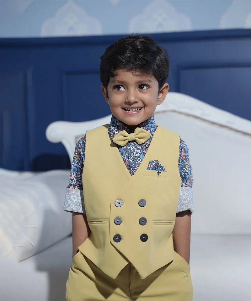 blue printed shirt with beige waist coat and a bow paired with beige pants for boys for parties & wedding