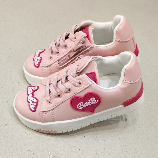 Pink sneakers with a heart-shaped Barbie logo on a light background