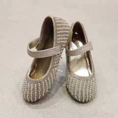 Pair of embellished shoes on a beige background