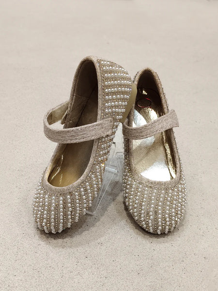 Pair of embellished shoes on a beige background