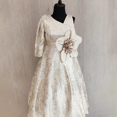 White lace dress with a floral detail on a mannequin against a neutral background