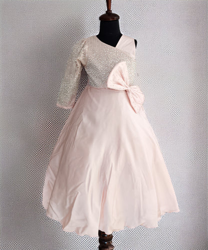 Mannequin wearing a dress with a textured top and pink skirt against a textured gray background