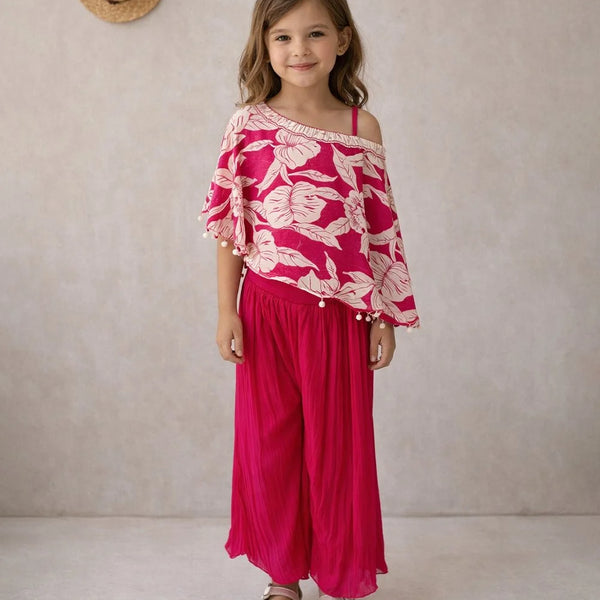 Young girl wearing a pink floral top and pants against a neutral background