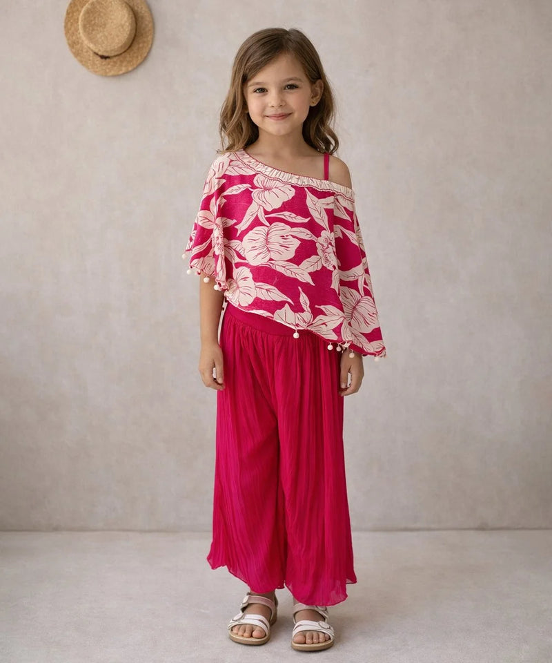 Young girl wearing a pink floral top and pants against a neutral background