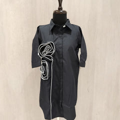 Black dress with white graphic on a mannequin against a beige background