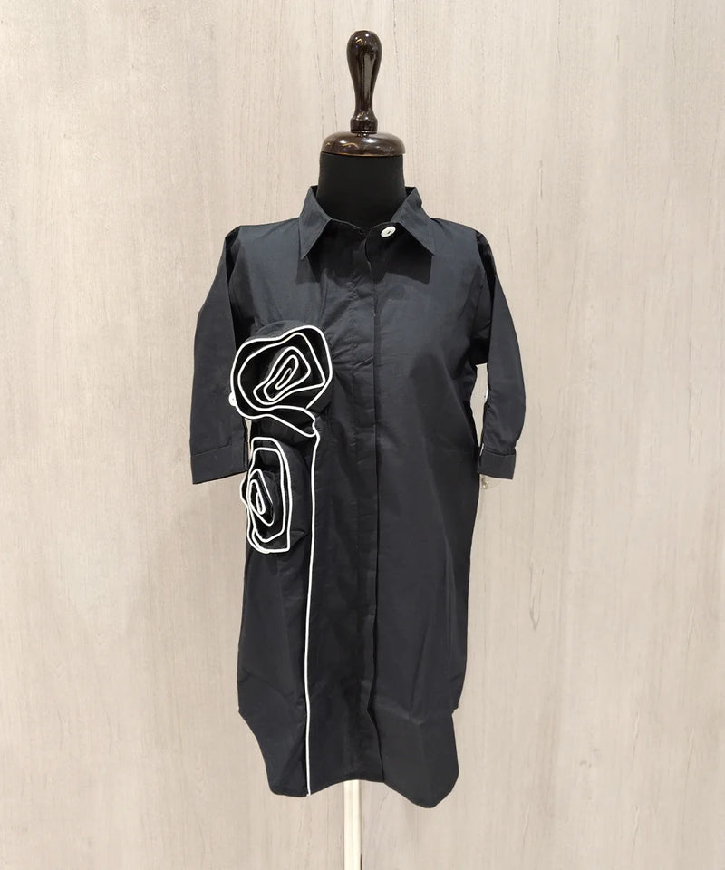 Black dress with white graphic on a mannequin against a beige background