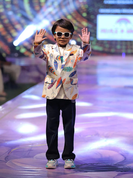Child model on a fashion show runway wearing a colourful printed blazer.