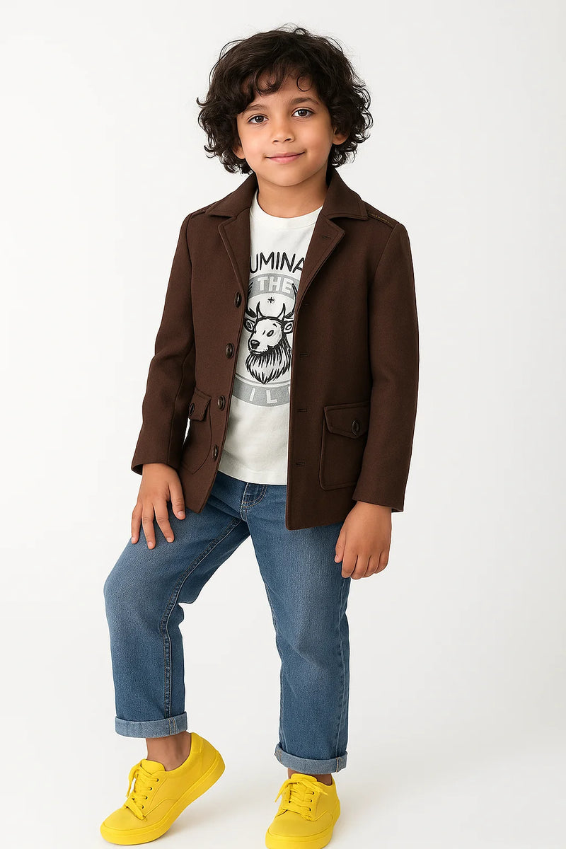 Child wearing a brown coat, white t-shirt with graphic design, blue jeans, and yellow shoes on a white background