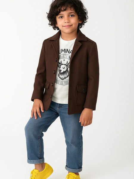 Child wearing a brown coat, white t-shirt with graphic design, blue jeans, and yellow shoes on a white background