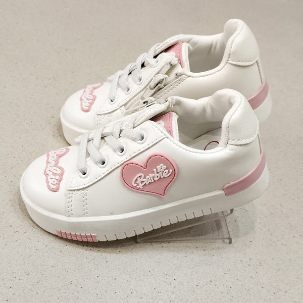 White sneakers with pink accents and a heart-shaped Barbie logo on a light gray background