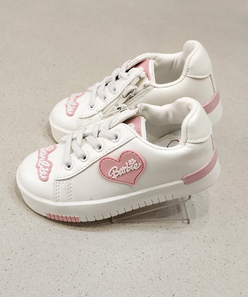 White sneakers with pink accents and a heart-shaped Barbie logo on a light gray background