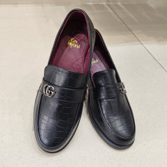 Pair of black leather loafers with a crocodile texture on a light gray surface.