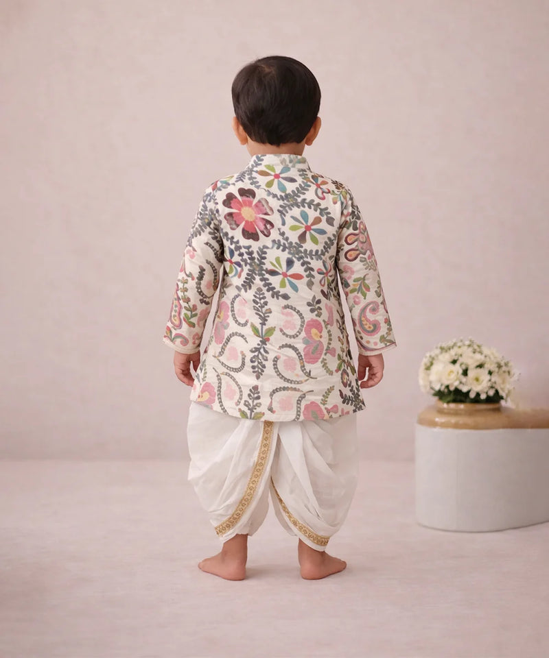 Child wearing a traditional outfit with floral patterns on a plain background