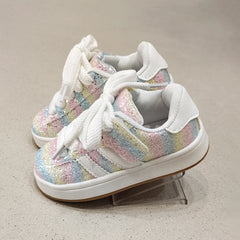 Pair of colorful sneakers with white laces on a neutral background