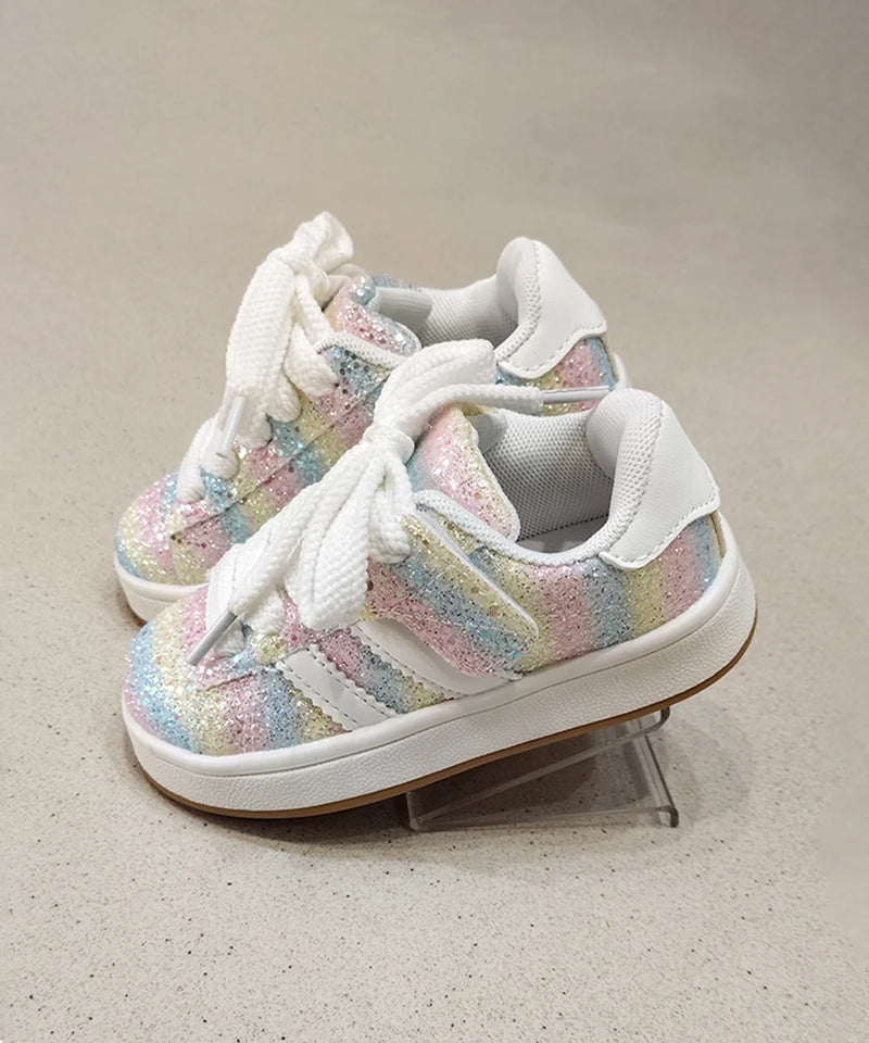 Pair of colorful sneakers with white laces on a neutral background