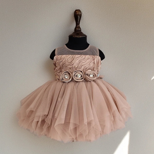 Pink dress with floral details on a mannequin against a plain background