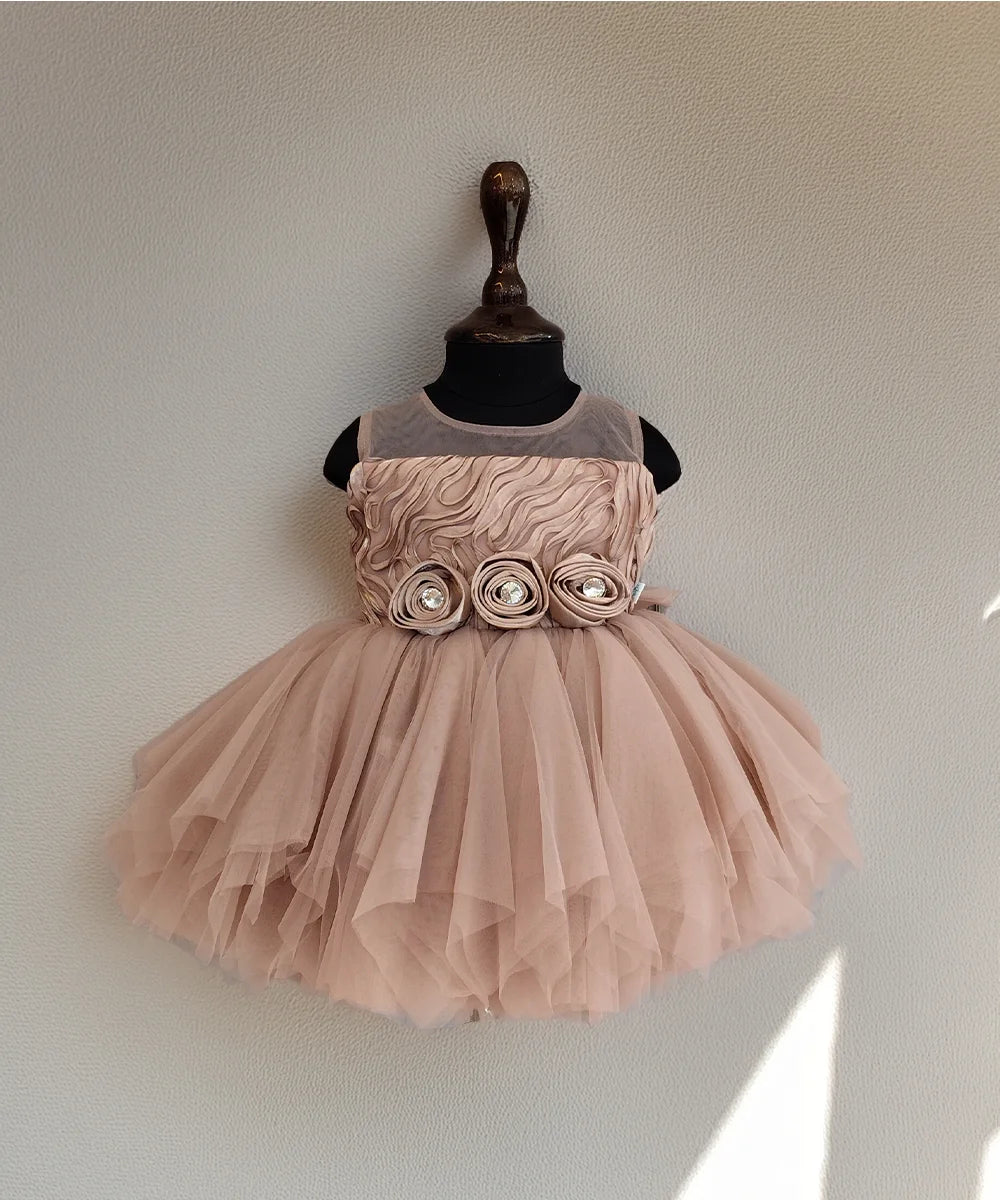 Pink dress with floral details on a mannequin against a plain background