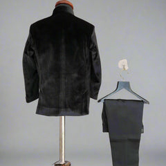 Black jacket on a mannequin and black pants on a hanger against a light background