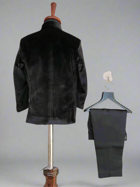 Black jacket on a mannequin and black pants on a hanger against a light background