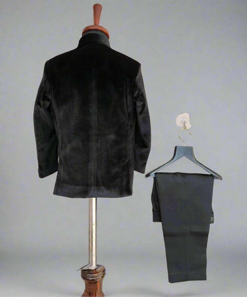 Black jacket on a mannequin and black pants on a hanger against a light background