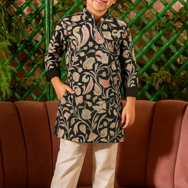 Child wearing a traditional outfit with a floral pattern standing in front of a green lattice wall.
