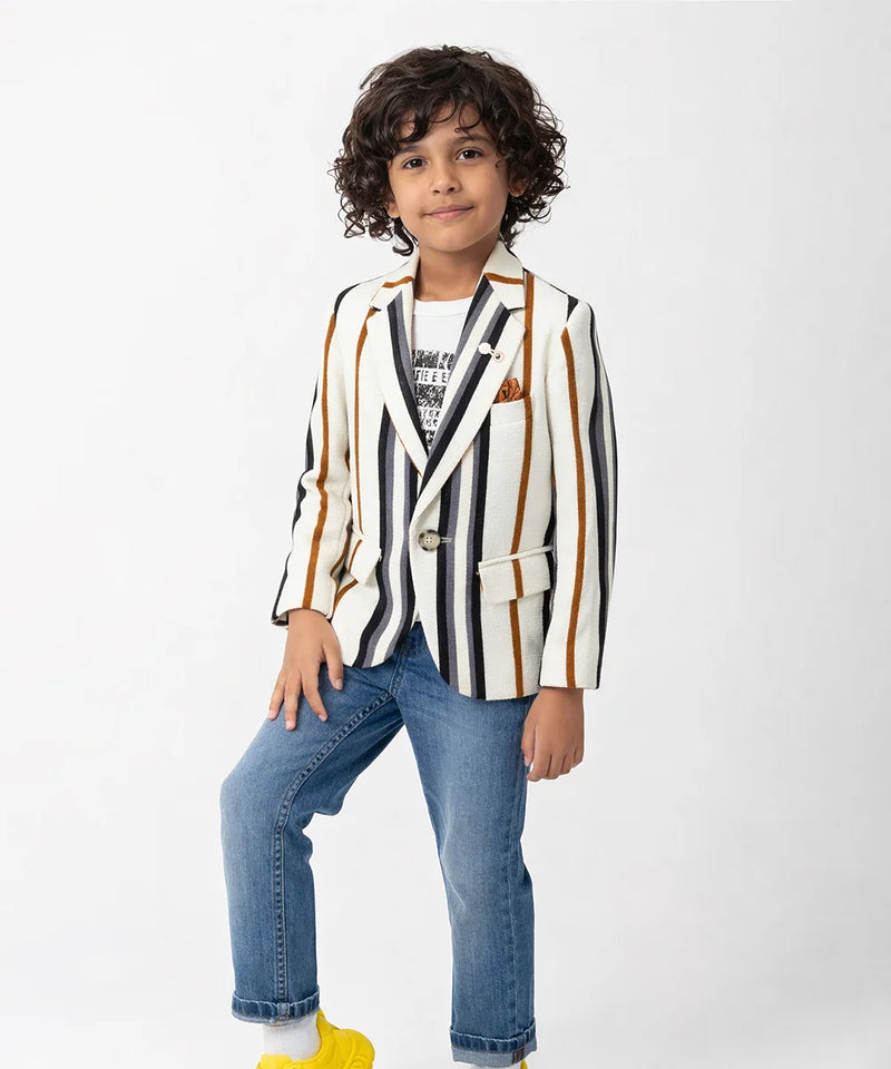 Child wearing a striped blazer and jeans on a white background