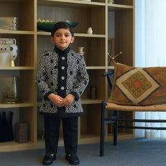 Child standing in a room with a bookshelf and chair in the background