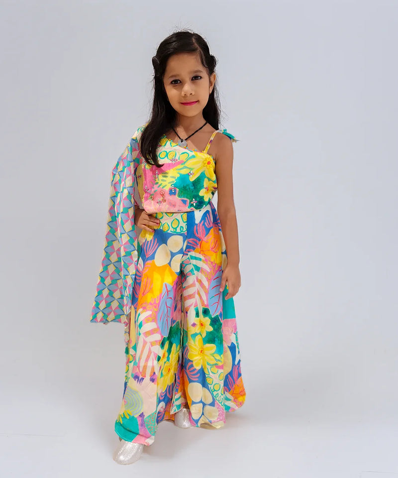 Young girl wearing a colorful floral outfit on a plain background