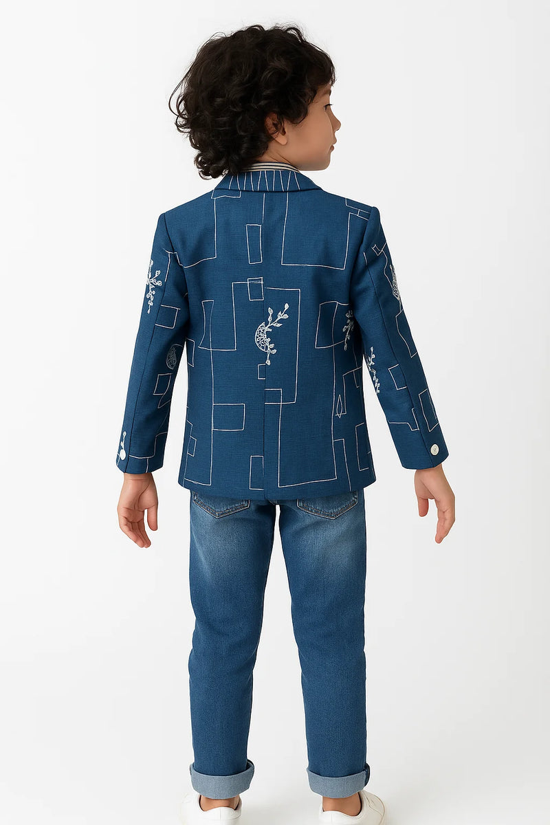 Child wearing a blue jacket with geometric patterns on a white background
