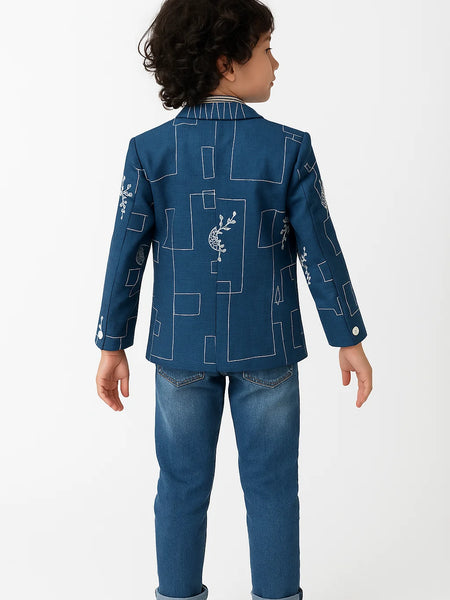 Child wearing a blue jacket with geometric patterns on a white background