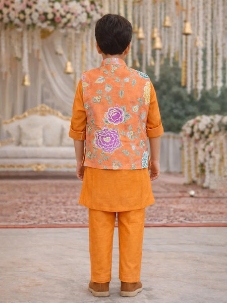 Child wearing an orange traditional outfit with a floral vest in a decorated setting
