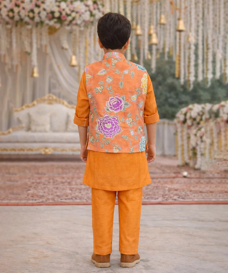 Child wearing an orange traditional outfit with a floral vest in a decorated setting