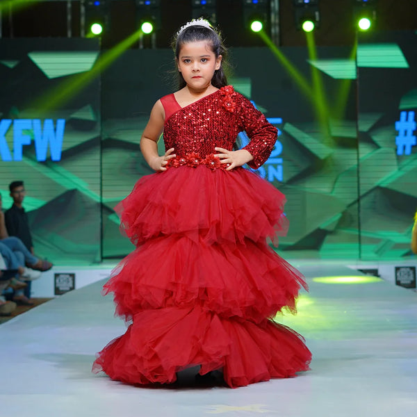 It’s a ruffle layered gown in maroon color that features big sequin bow at the back and floral detailing on the waist.